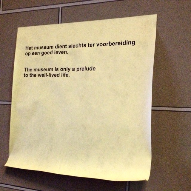 A giant post-it note on the walls of the Rijksmuseum, Amsterdam, saying: 'The museum is only a prelude the well-lived life' (Alain de Botton).