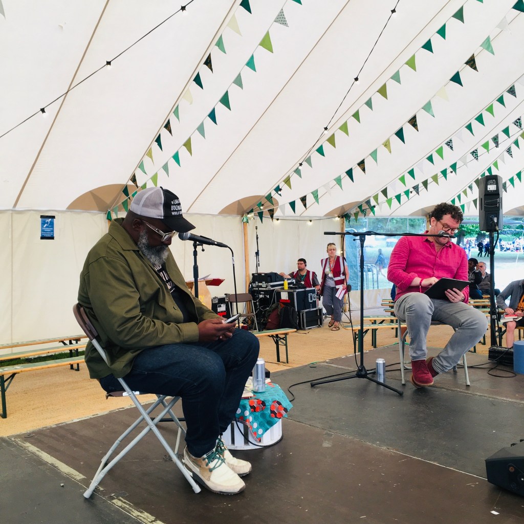 A picture of Roger Robinson and Pádraig Ó Tuama preparing to give a reading at Greenbelt festival, August 2022