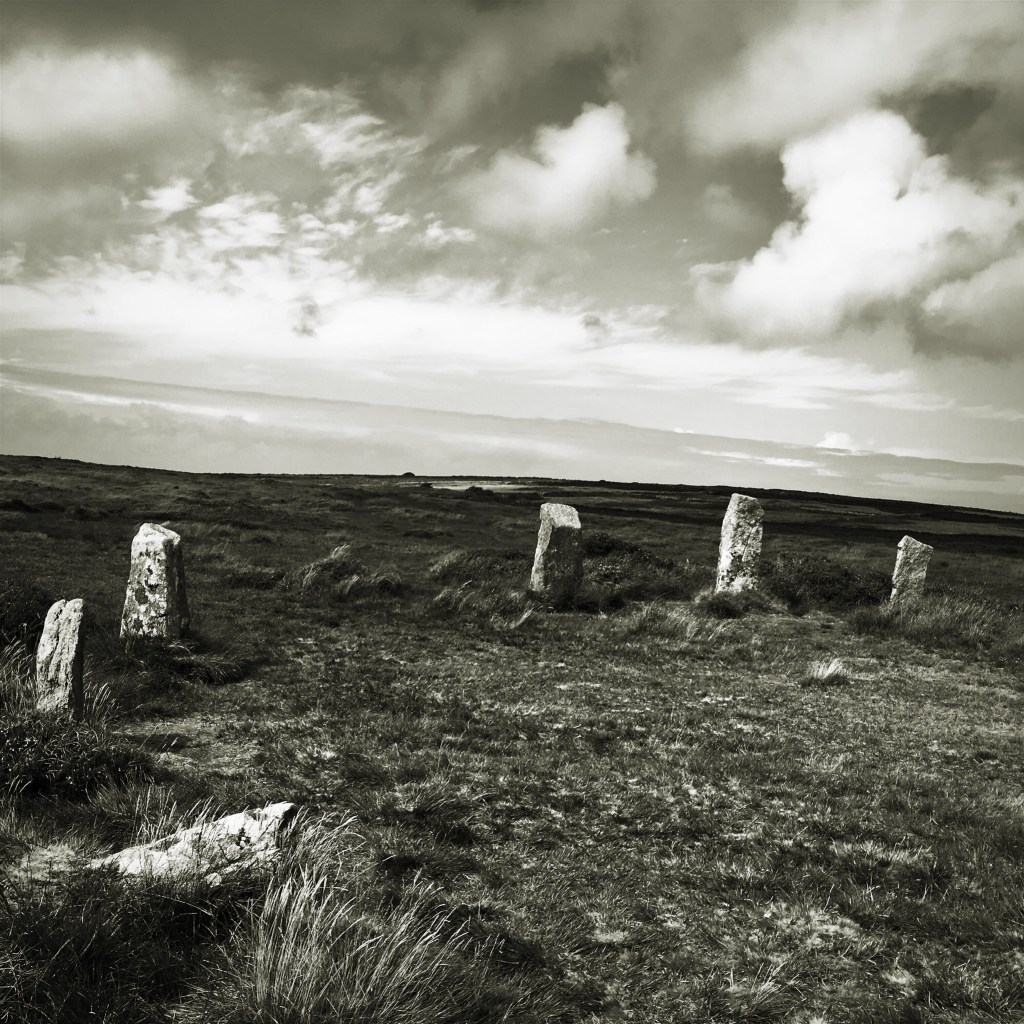 A black and white photo of the Nine Maidens standing stones in Cornwall